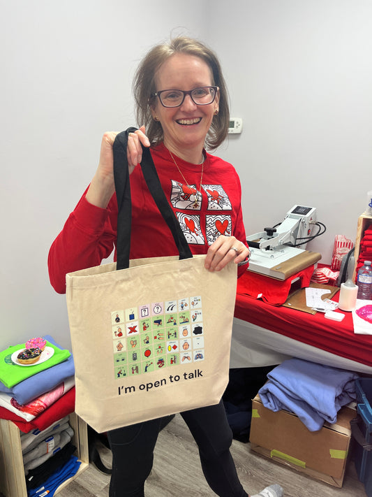 Sherry holding up an AAC  Tote Bag - I'm open to talk at Smile Therapy's 1st open house in 2025 