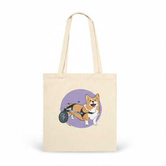 Beige tote bag with a corgi in a wheelchair design on a white background