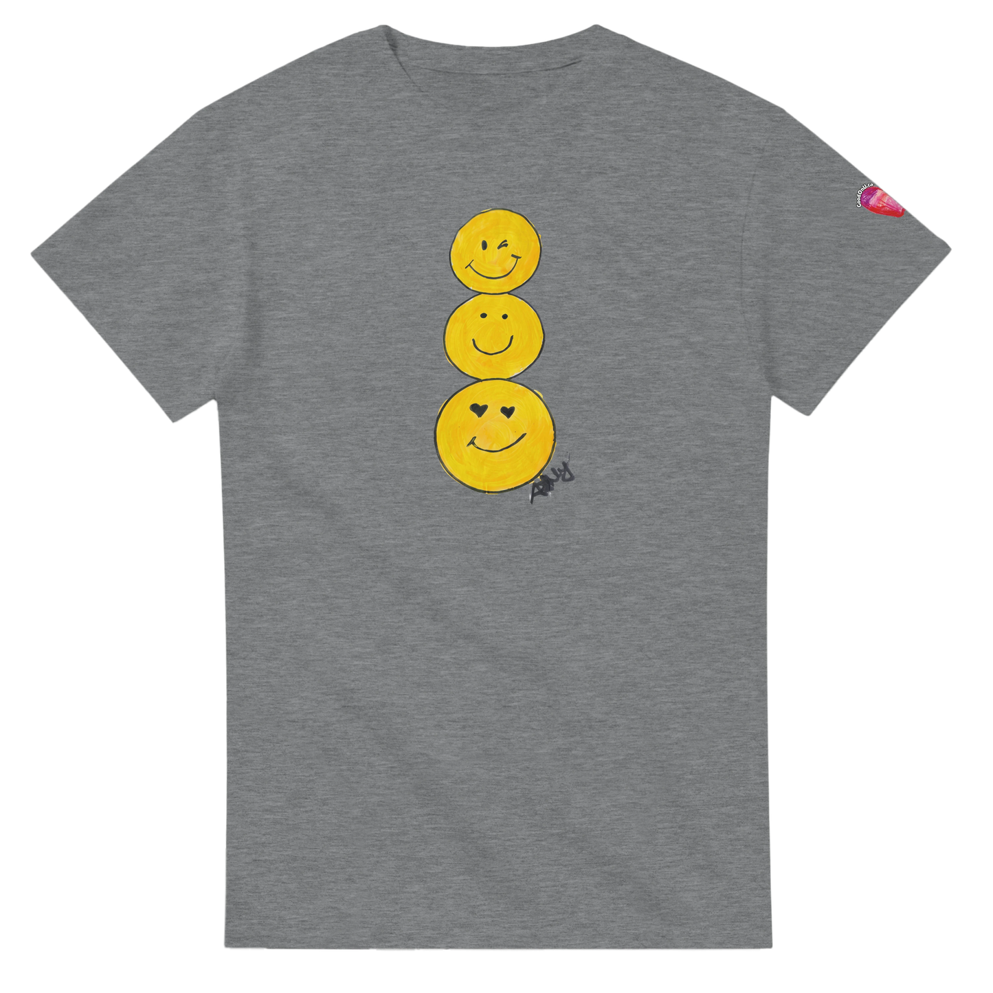 A heather gray short-sleeve T-shirt featuring a graphic of three stacked yellow smiley faces on the front, by Ashley Caldwell with a small pink heart patch on the left sleeve.
