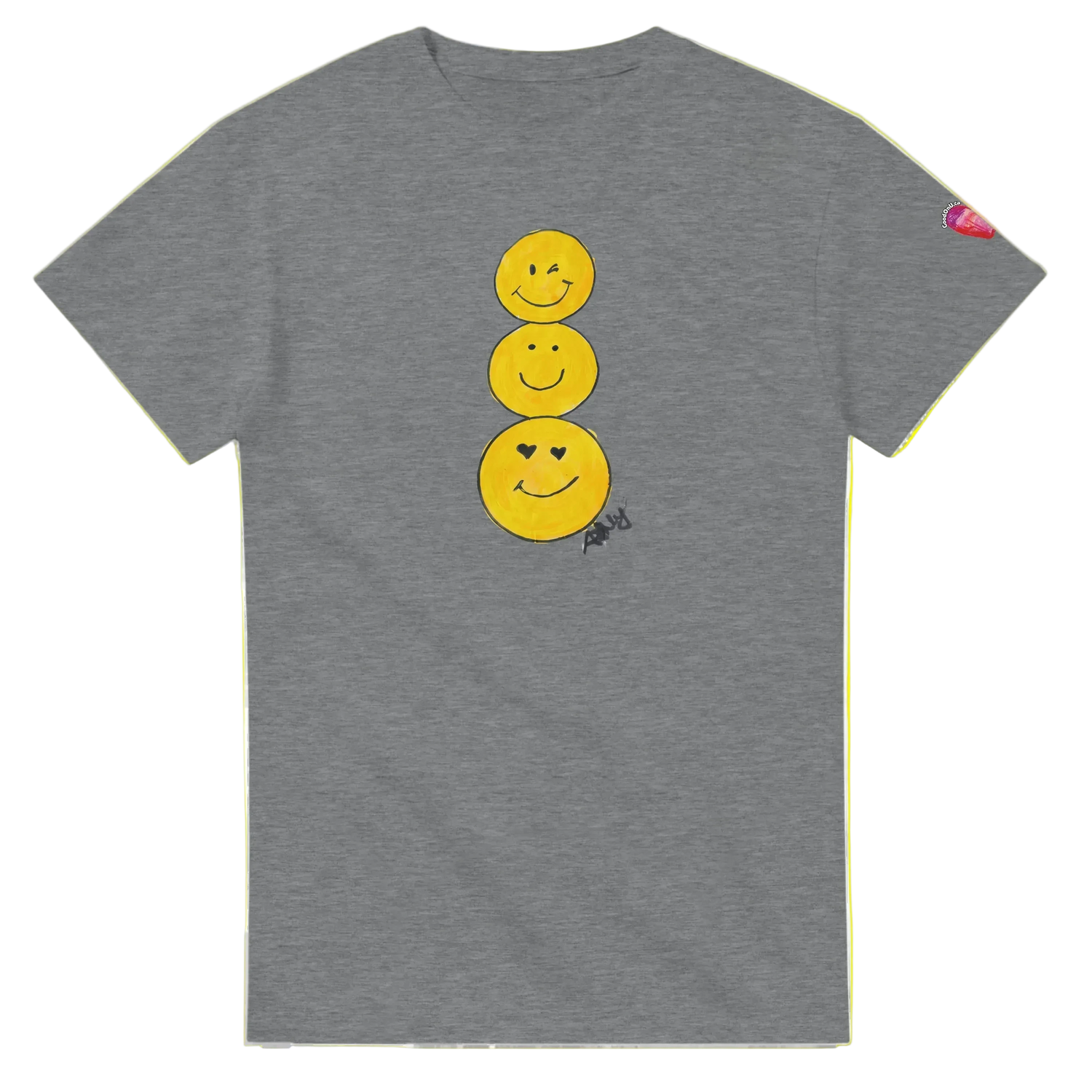A heather gray short-sleeve T-shirt featuring a graphic of three stacked yellow smiley faces on the front, by Ashley Caldwell with a small pink heart patch on the left sleeve.