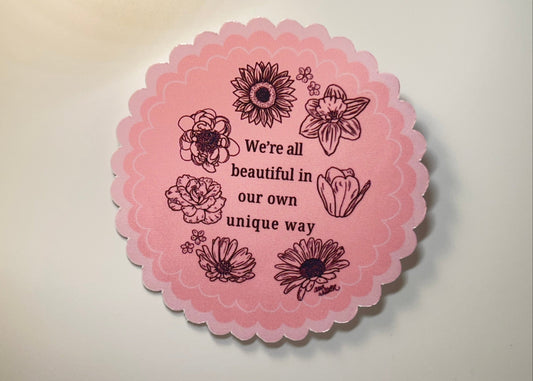 Pink ro all  sticker with various flowers which reads We're all beautiful in our own way. 